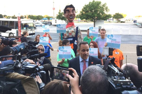 Protestors behind Gov. Bevin at Farm Bureau Breakfast