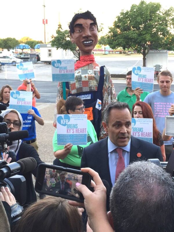 Protestors behind Gov. Bevin at Farm Bureau Breakfast