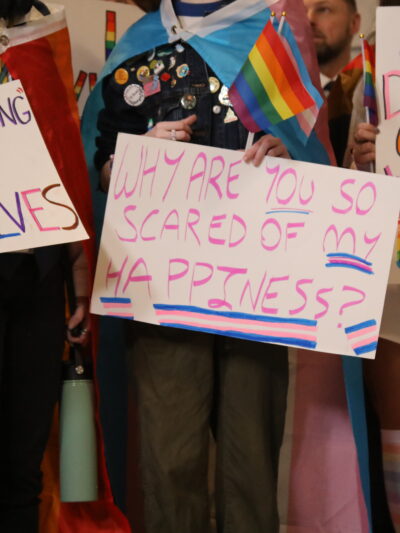 People hold trans rights signs at the Kentucky Capitol Rotunda for the 2023 Fairness Rally