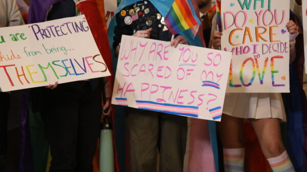 People hold trans rights signs at the Kentucky Capitol Rotunda for the 2023 Fairness Rally