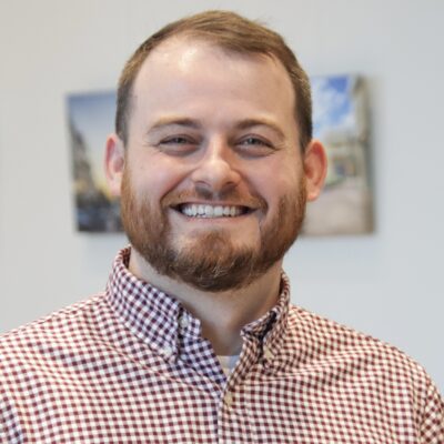 rob wears a plaid shirt and smiles with red hair