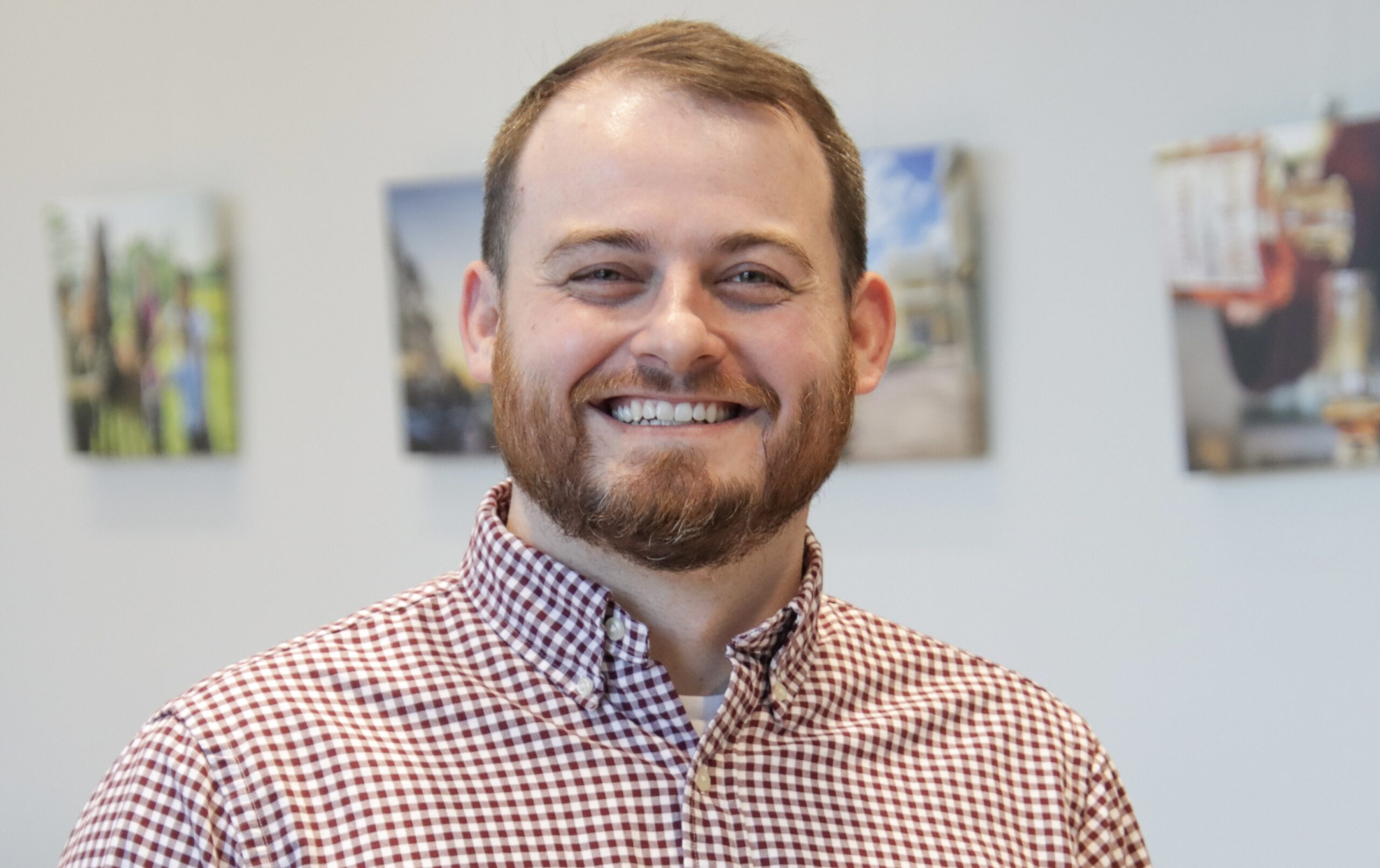 rob wears a plaid shirt and smiles with red hair