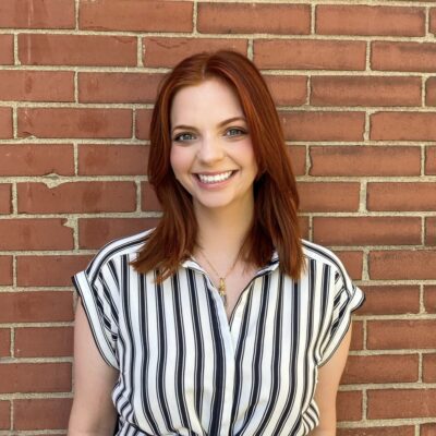 taylor smiles in a striped shirt with long red hair