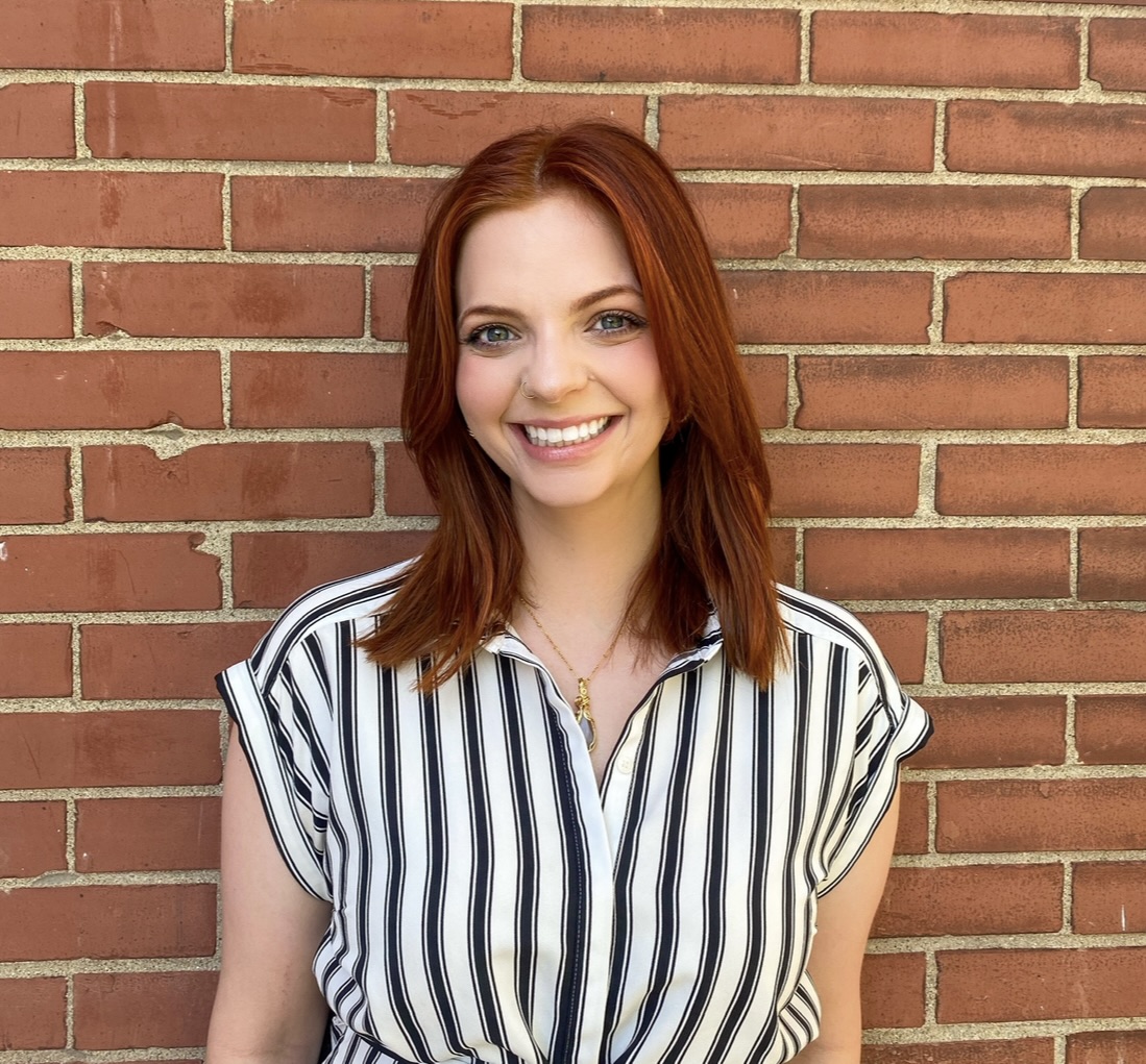 taylor smiles in a striped shirt with long red hair