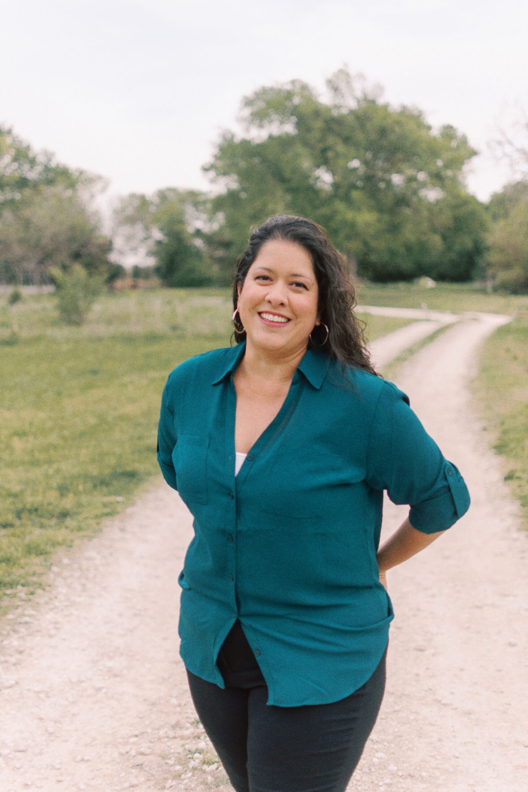 shanna stands with her arms behind her back smiling