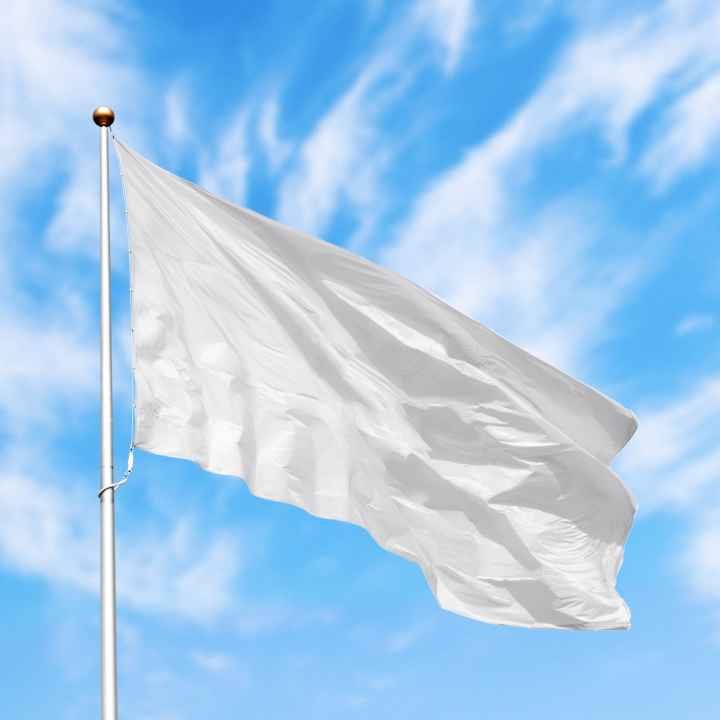 A white flag flies over blue skies in background.