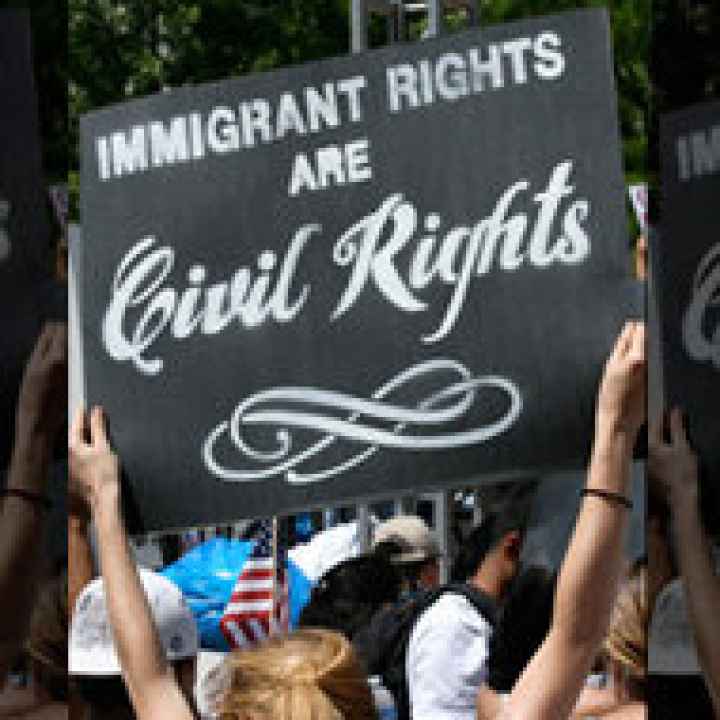 Woman holding sign that says &quot;Immigrant Rights are Civil Rights.&quot;